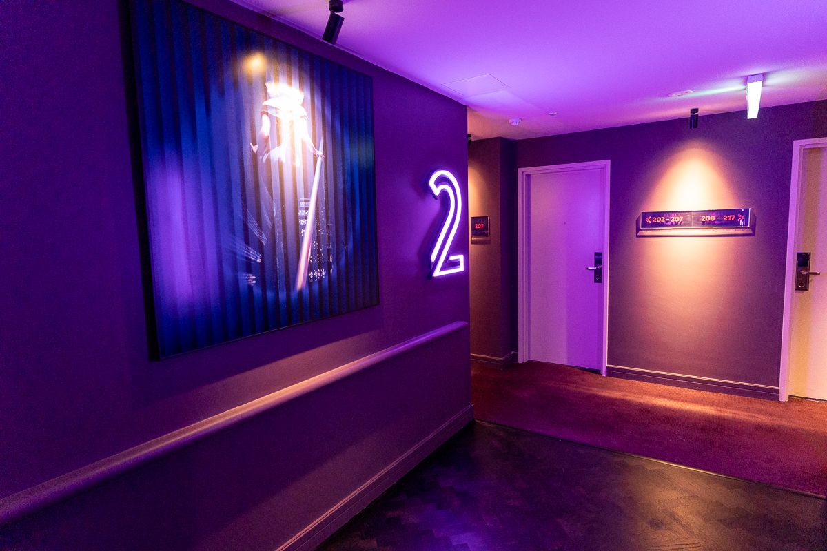Purple-lit corridor with a neon floor number at Hotel Indigo Sydney Potts Point