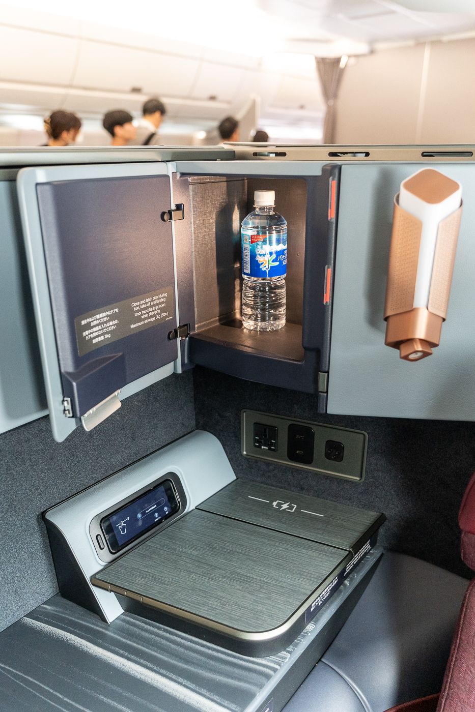 Side storage, water bottle and charging pad at a Japan Airlines A350-1000 business class seat