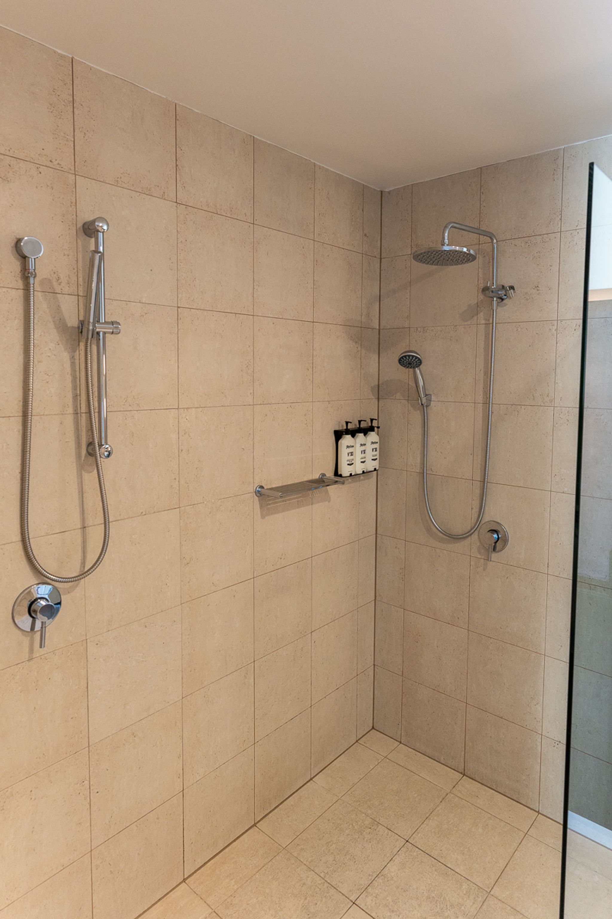 Tiled shower with rain and hand showerheads at Hotel Indigo Sydney Potts Point