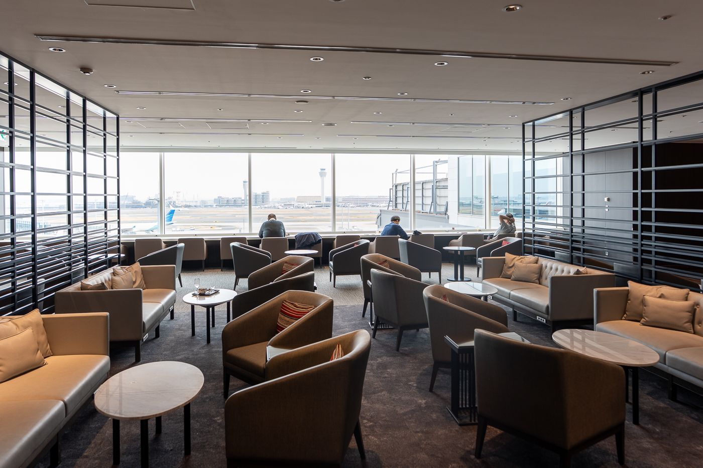 Japan Airlines lounge in Tokyo with armchairs and apron views