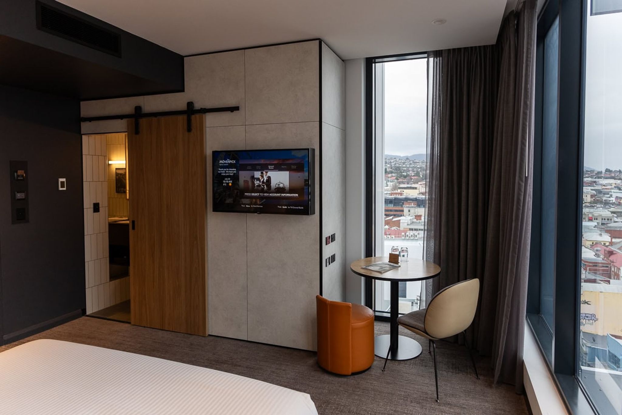 Mövenpick Hobart room with a sliding barn door, TV and window seating