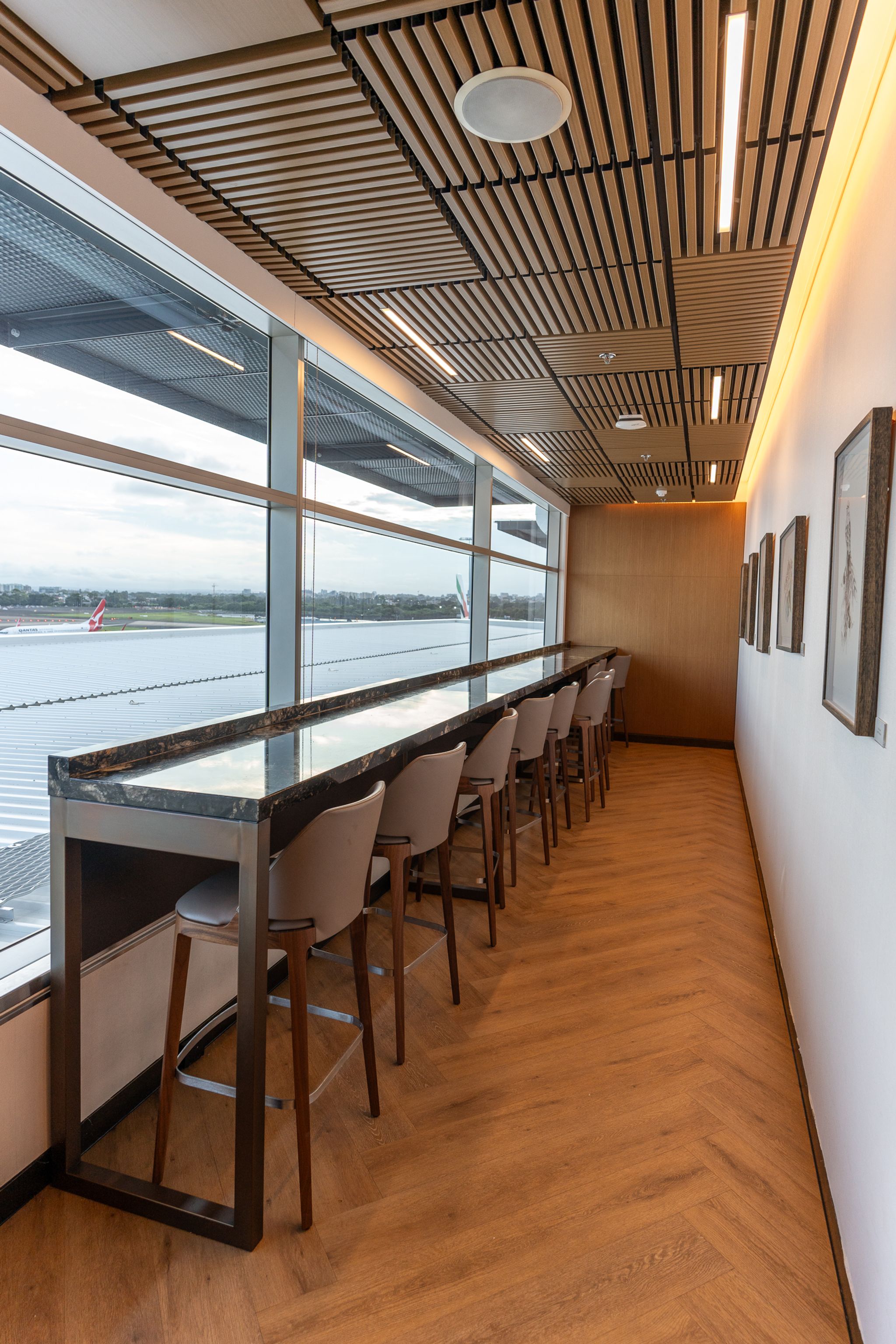 Row of barstools with airport views in the SilverKris Lounge, Sydney
