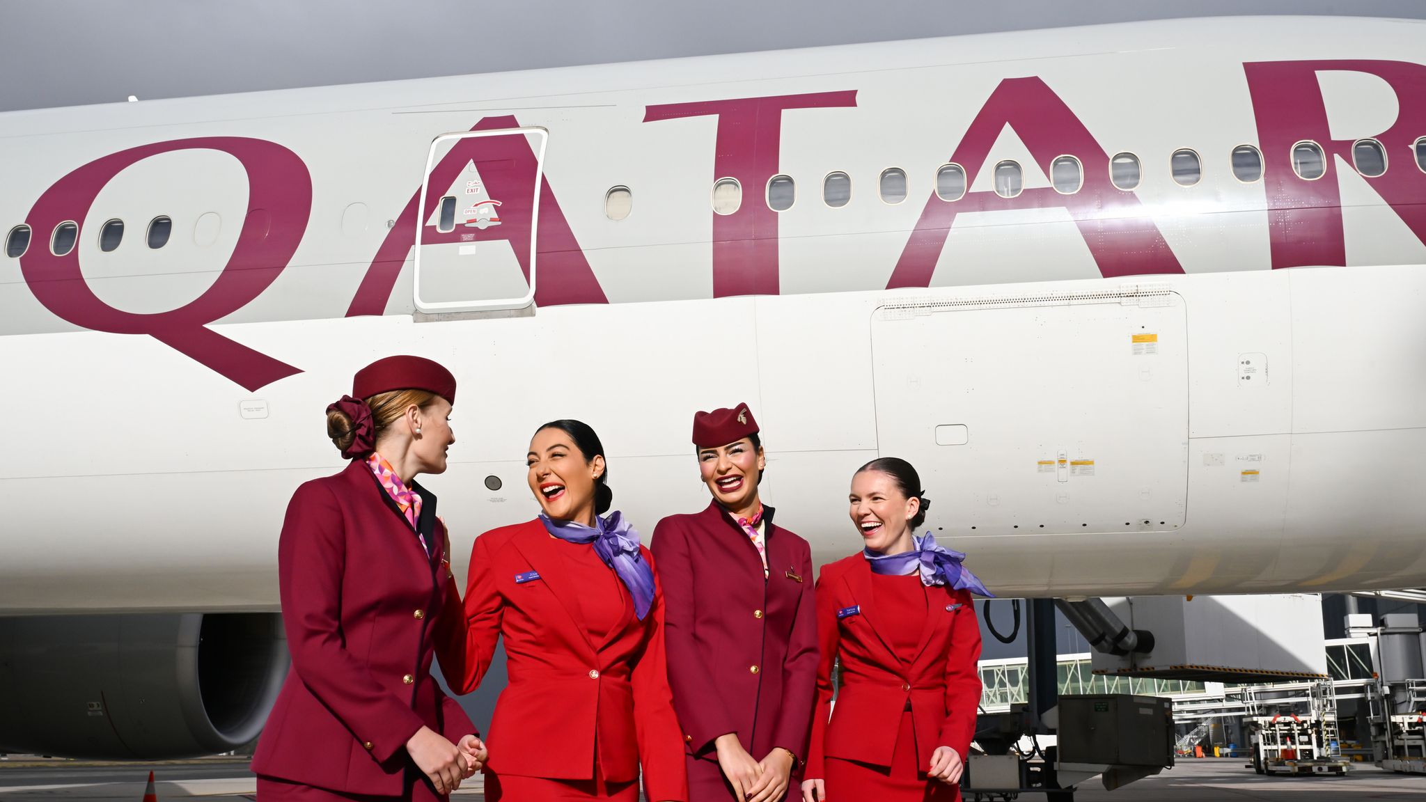 Qatar Airways and Virgin Australia cabin crew in front of a Qatar Airways aircraft