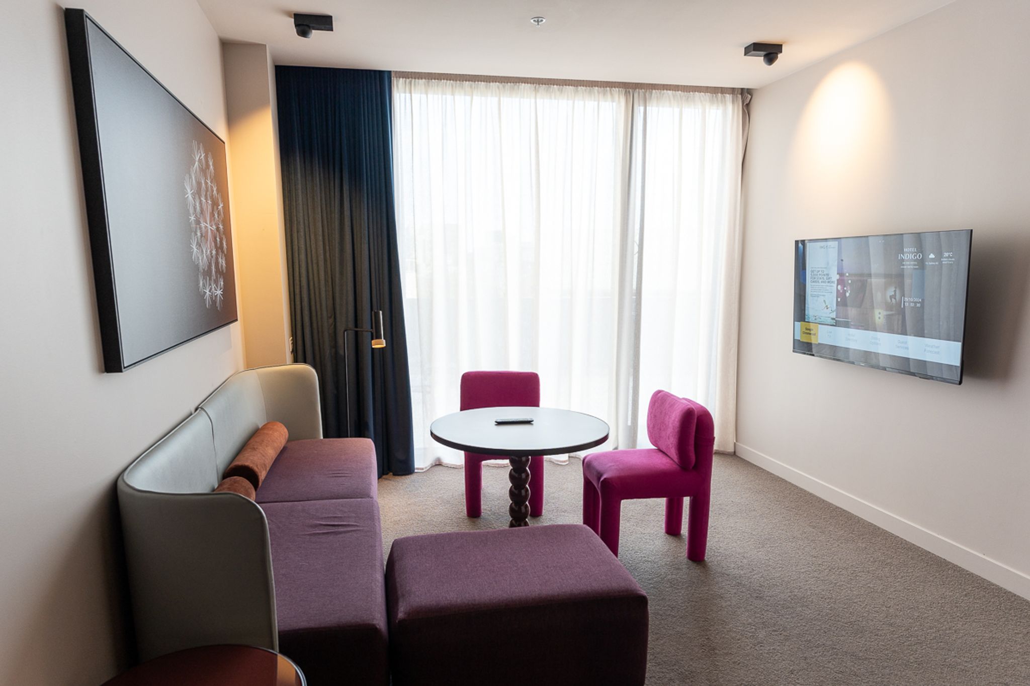Lounge with sofa and pink chairs in the Terrace Suite at Hotel Indigo Sydney