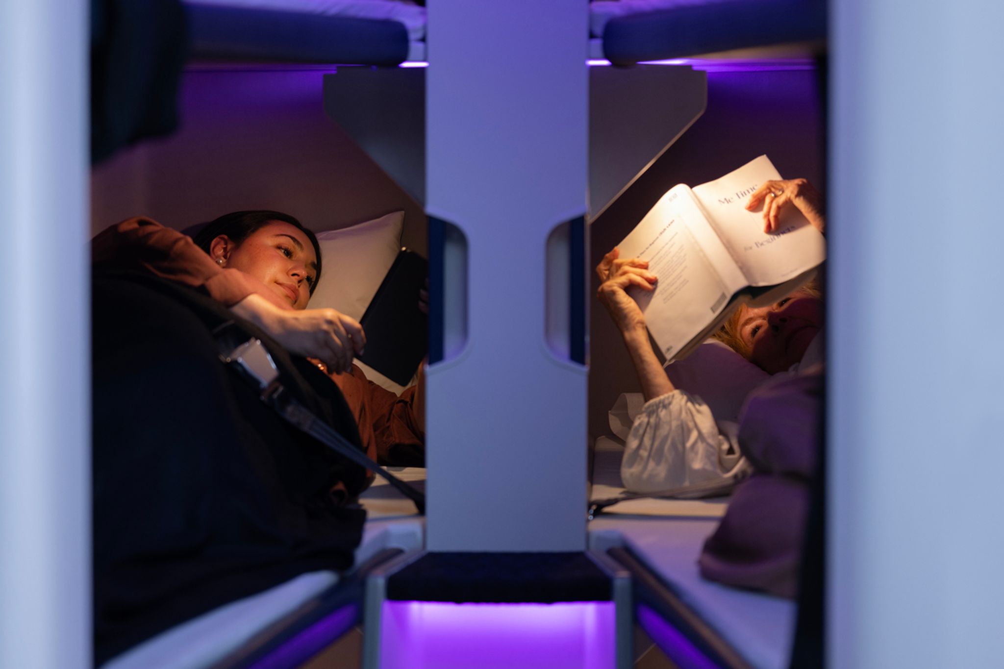 Two passengers resting in Air New Zealand Skynest economy sleep pods