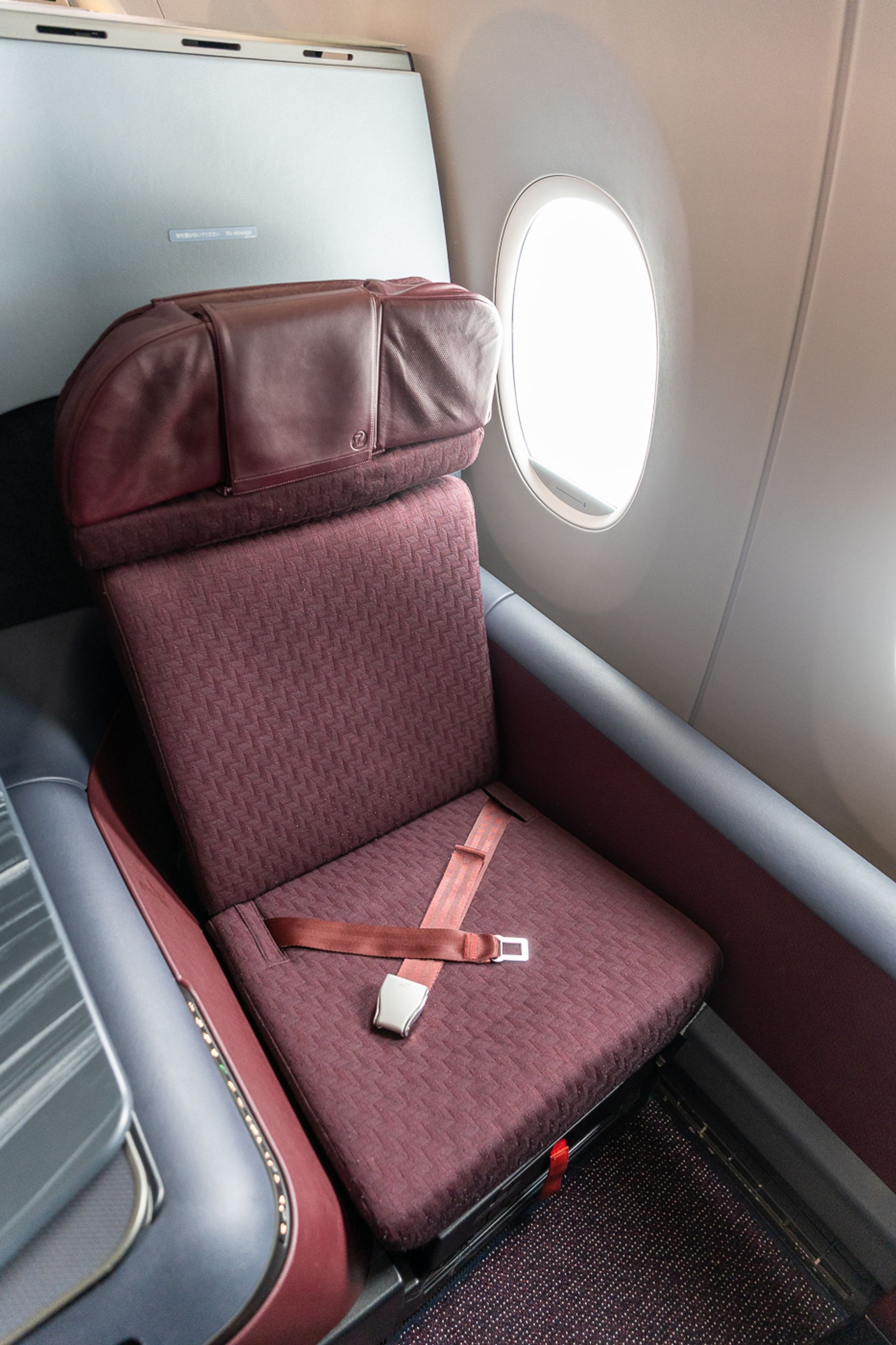 Japan Airlines A350-1000 business class seat in red fabric beside the window