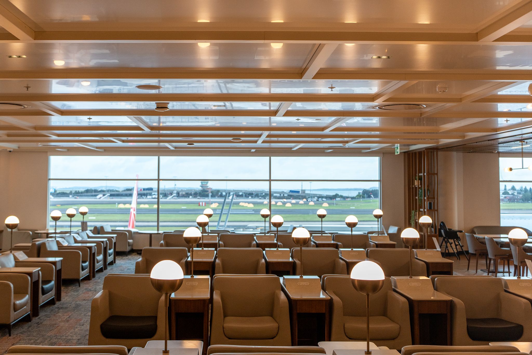 Armchairs with lamps overlooking the airfield in the SilverKris Lounge, Sydney