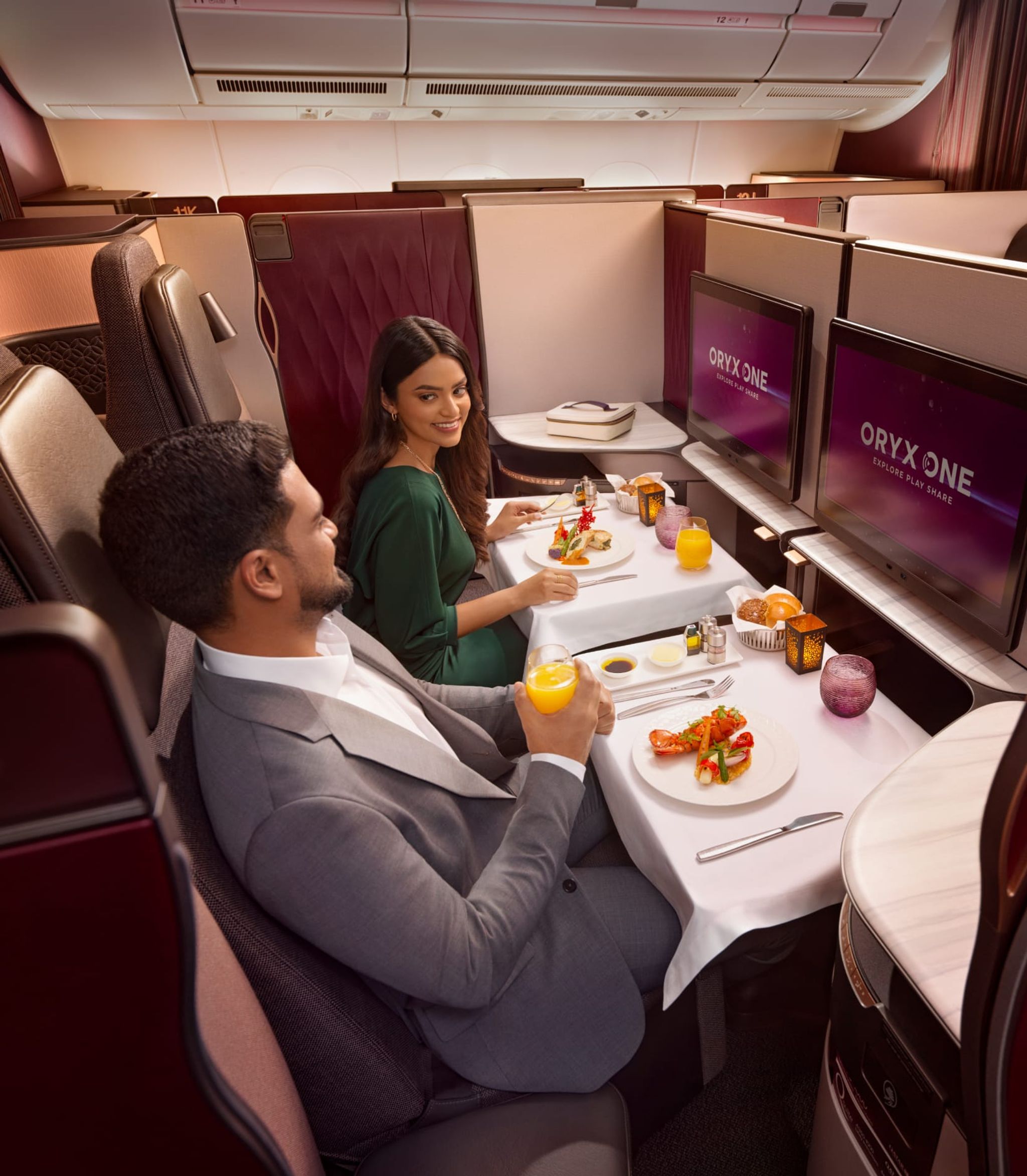 Couple dining in Qatar Airways Qsuite business class