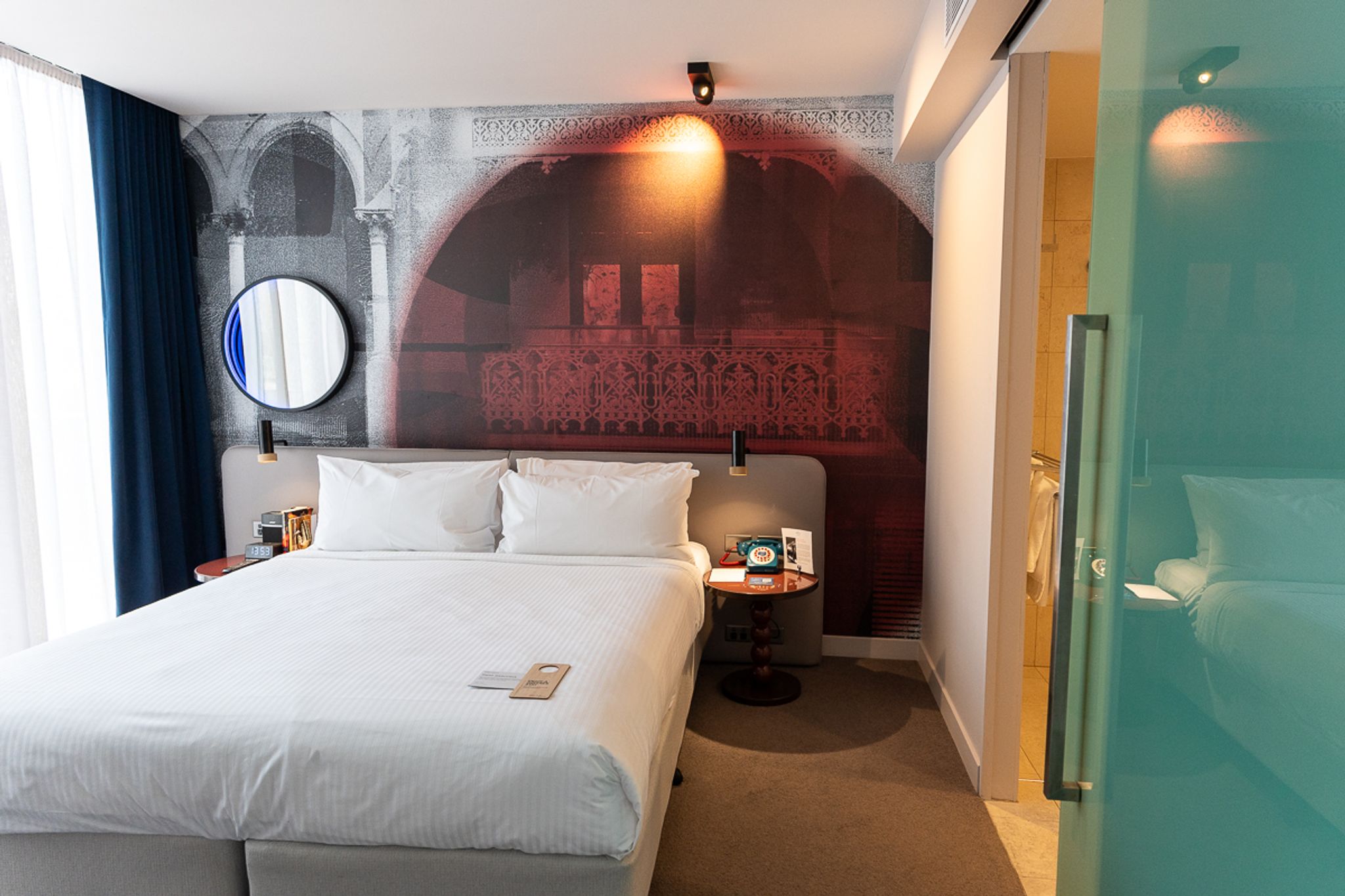 King bed with a mural wall in a room at Hotel Indigo Sydney Potts Point