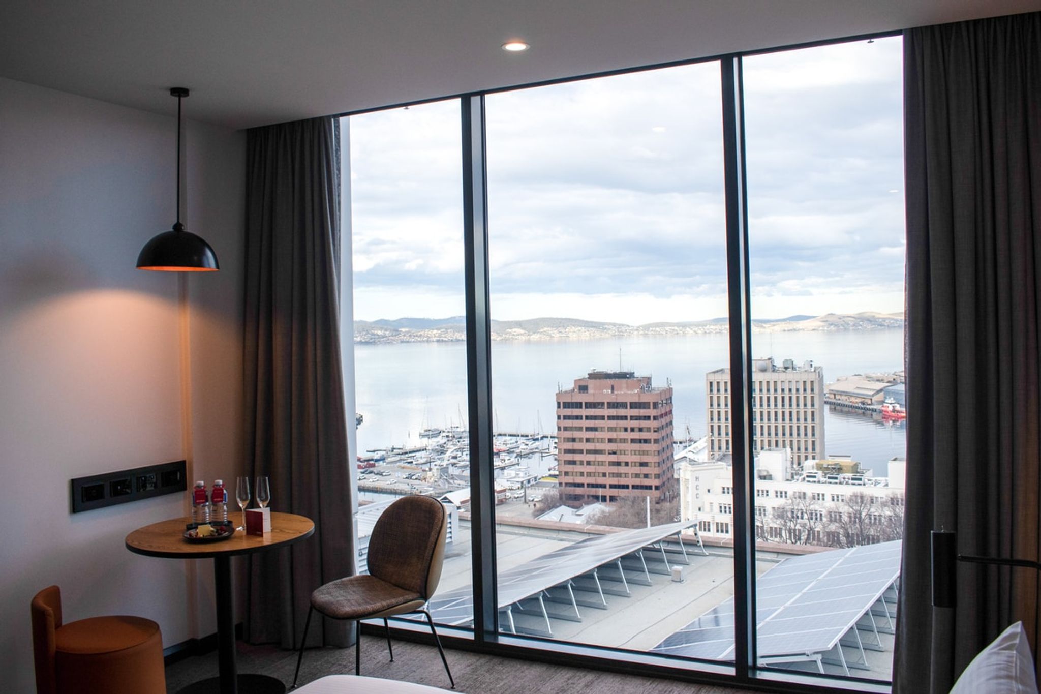 Mövenpick Hobart room with a small table by floor-to-ceiling harbour view windows