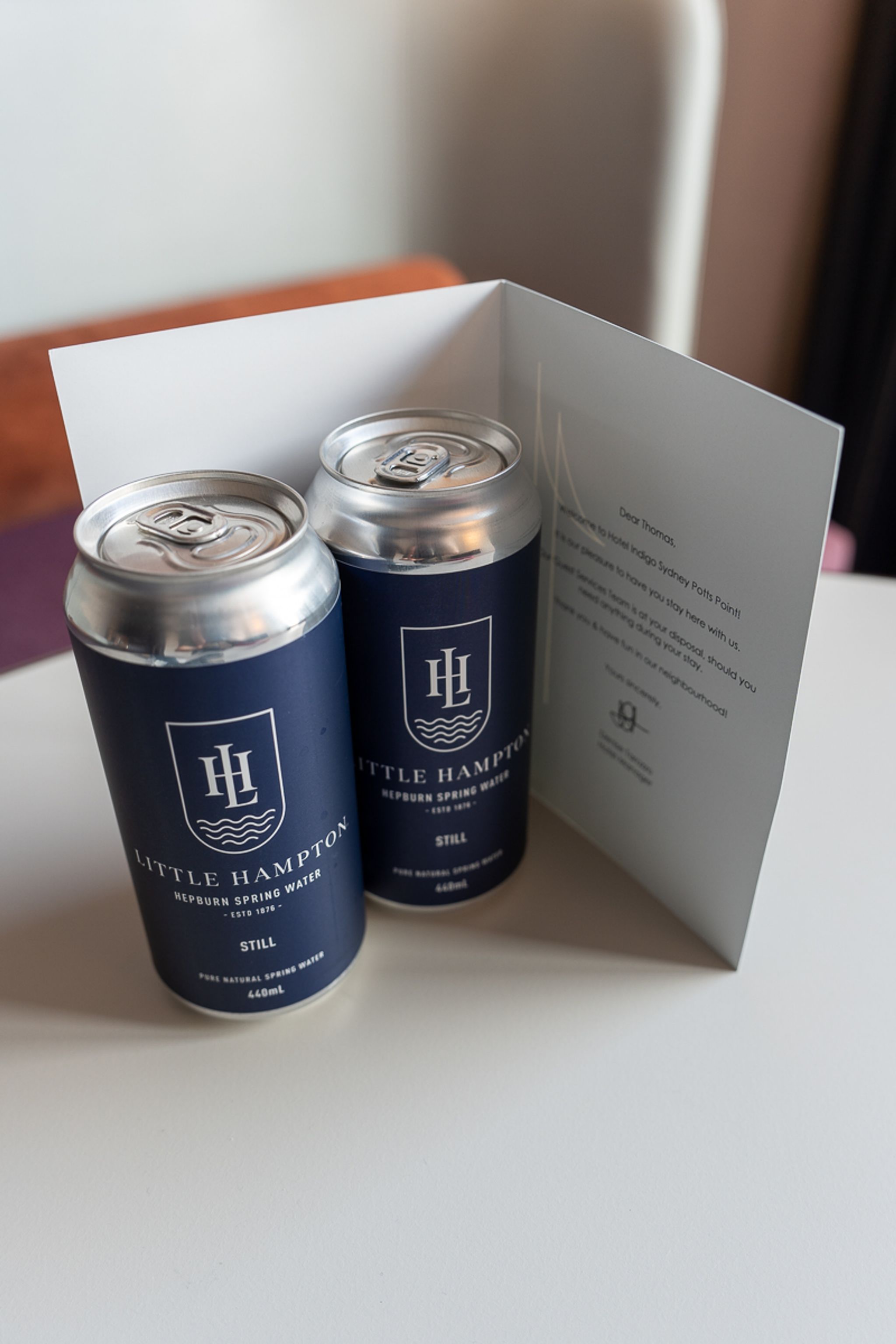 Two cans of Little Hampton spring water with a welcome card