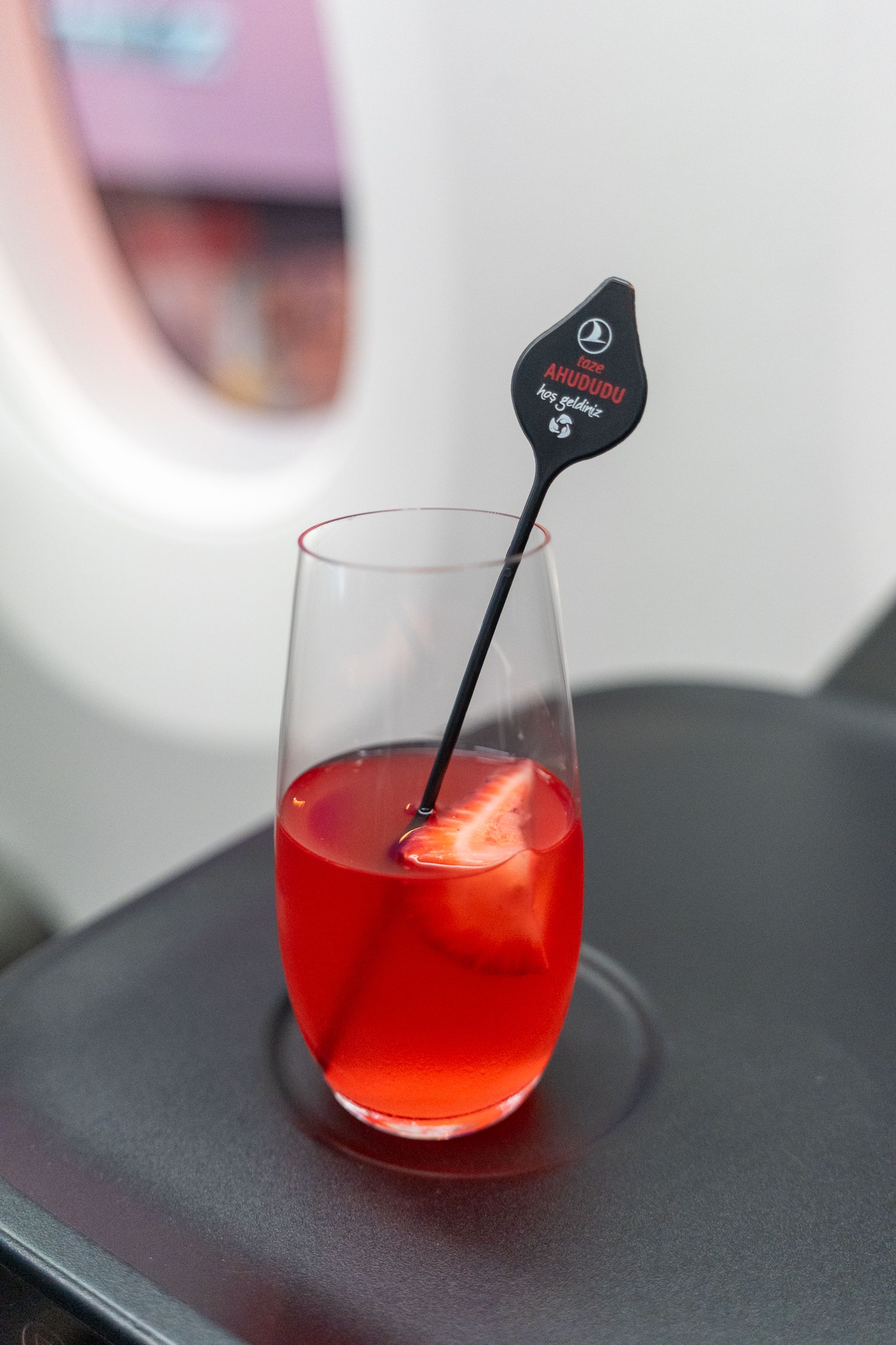 Red drink with a Turkish Airlines stirrer