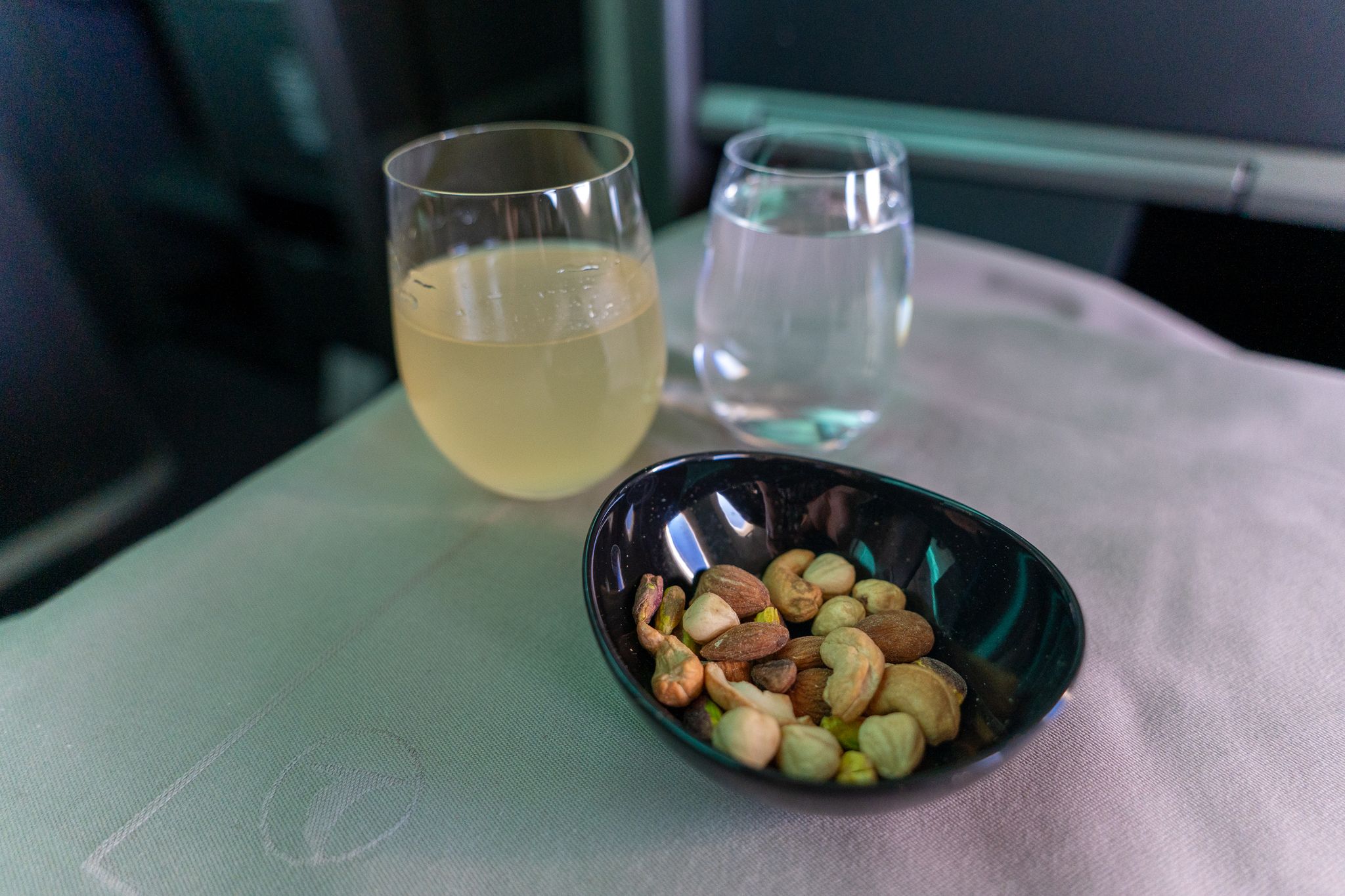 Drink and mixed nuts on the tray table in Turkish Airlines business class
