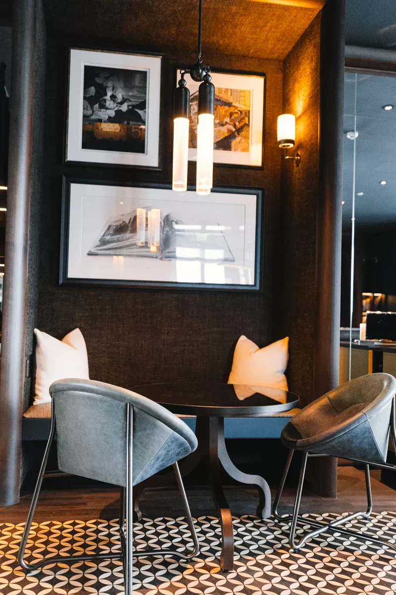 Seating nook with leather chairs and framed photos at Rosewood Hong Kong