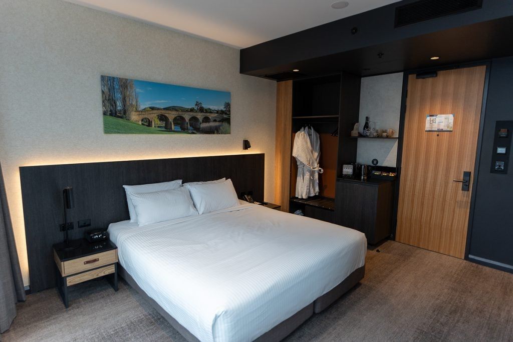 Deluxe Harbour View room at Mövenpick Hobart with a king bed and wardrobe