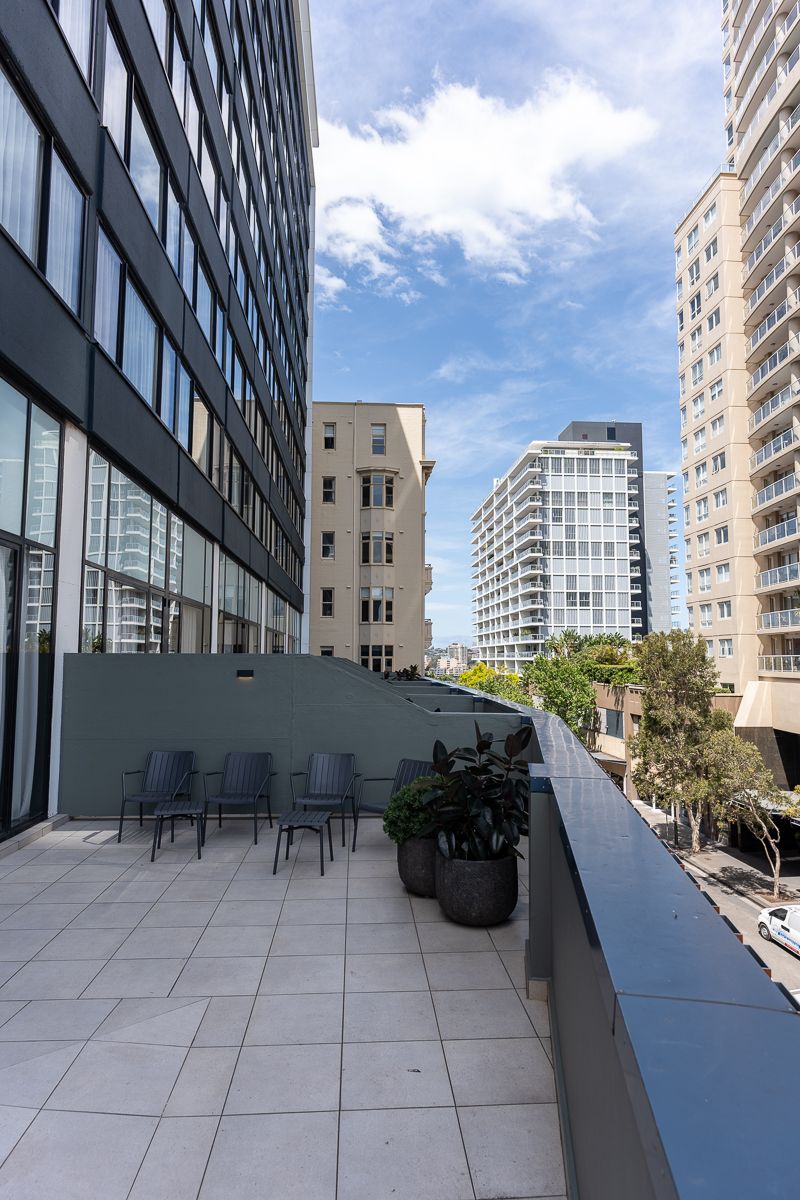 Terrace with outdoor chairs and plants at Hotel Indigo Sydney Potts Point