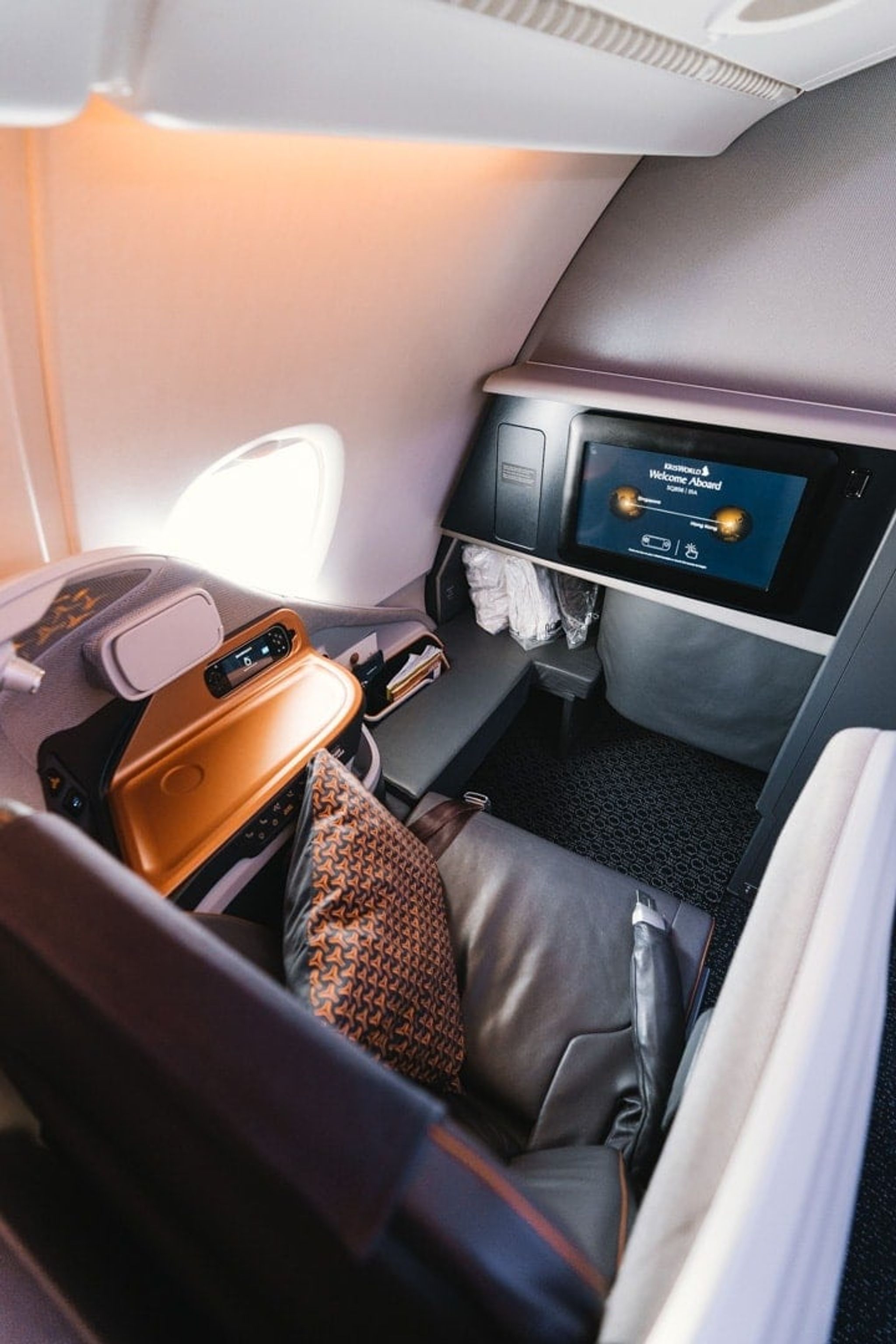 Singapore Airlines business class seat with a cushion and seatback screen