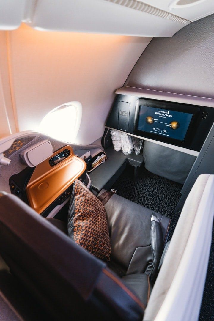 Singapore Airlines business class seat with a cushion and seatback screen