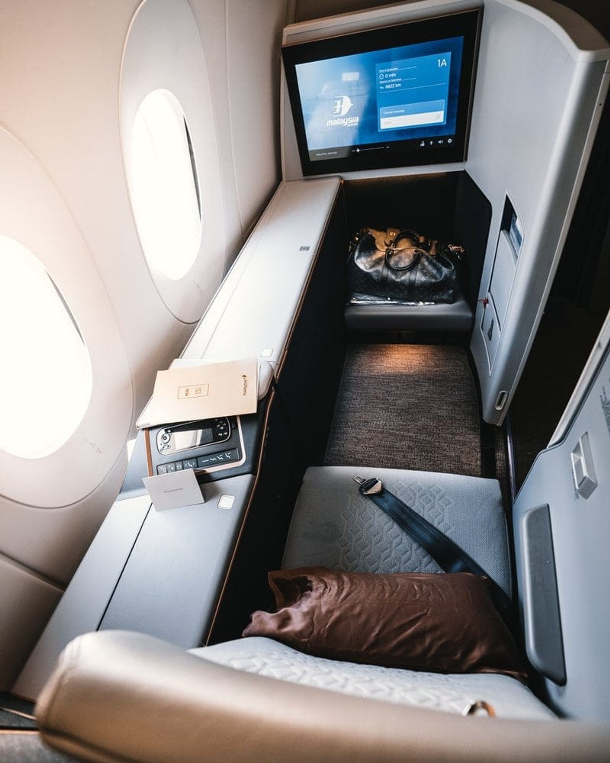 Lie-flat business class seat with a personal screen beside the window