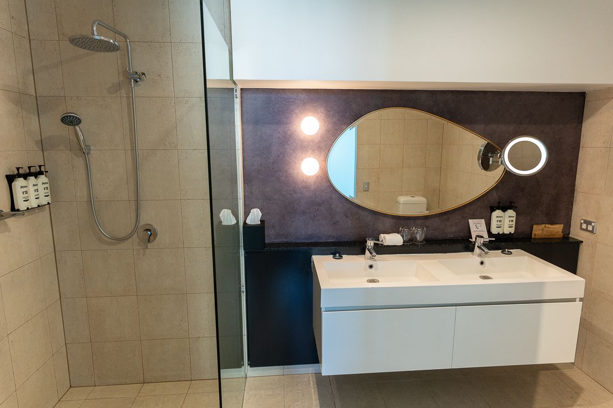 Bathroom at Hotel Indigo Sydney with a double vanity and walk-in shower
