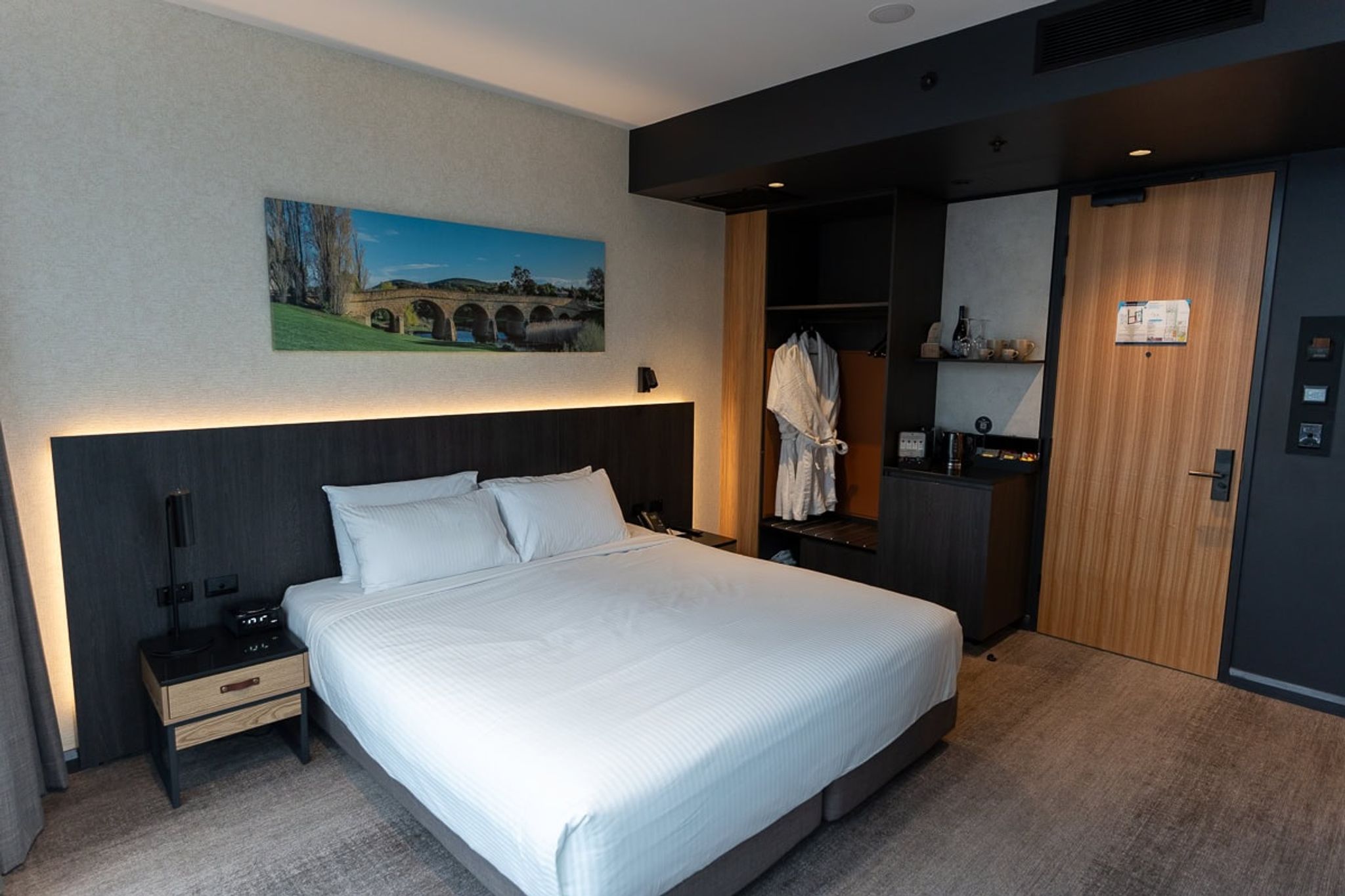 King bed with a lit headboard in a Mövenpick Hobart room